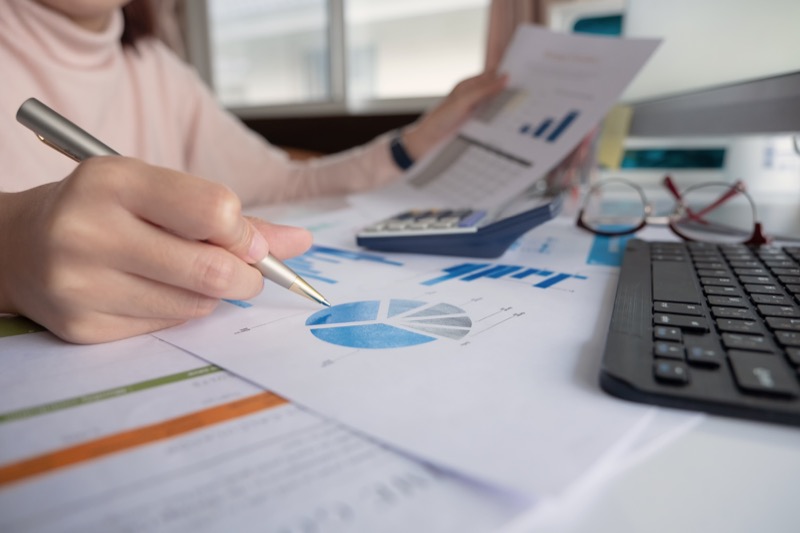woman investment consultant analyzing company annual financial report balance sheet statement working with documents graphs. Concept picture of business, market, office, tax.